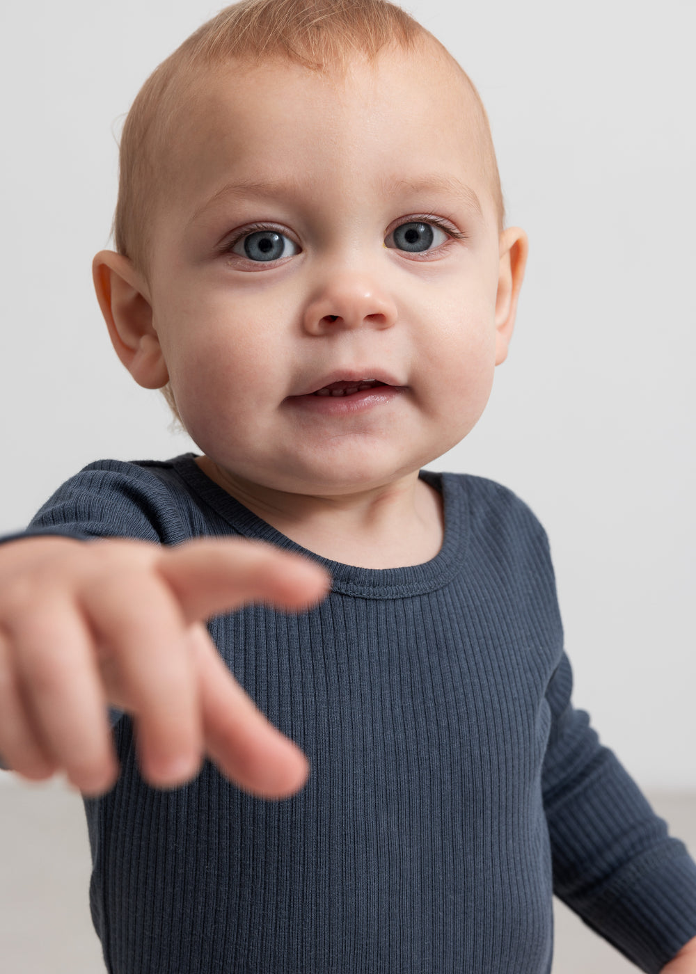Langærmet bodystocking i mørk blå ribstrik på baby, set forfra