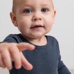 Langærmet bodystocking i mørk blå ribstrik på baby, set forfra