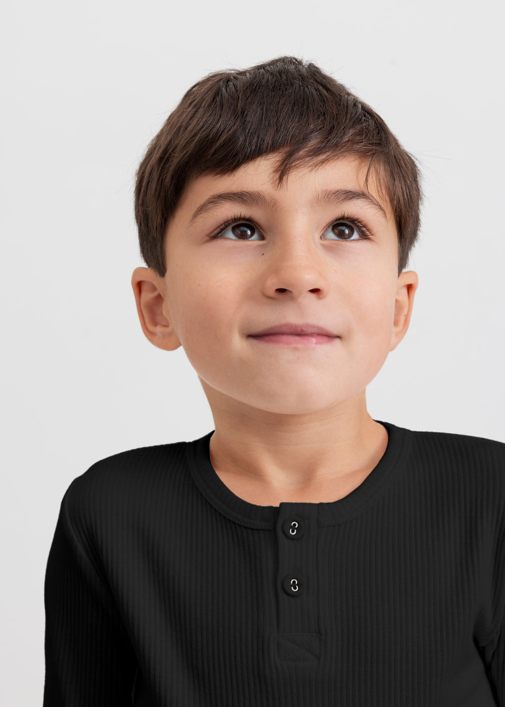 Sort langærmet T-shirt på model med knaplukning foran og ribbet overflade
