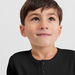 Sort langærmet T-shirt på model med knaplukning foran og ribbet overflade