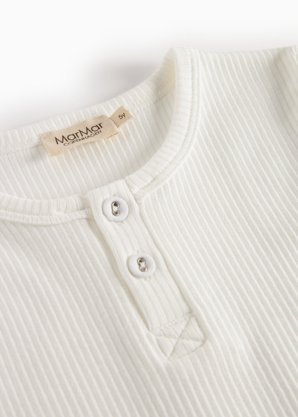 Cremefarvet t-shirt med rund hals og knapstolpe med to synlige knapper