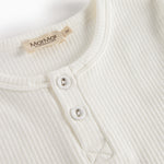 Cremefarvet t-shirt med rund hals og knapstolpe med to synlige knapper