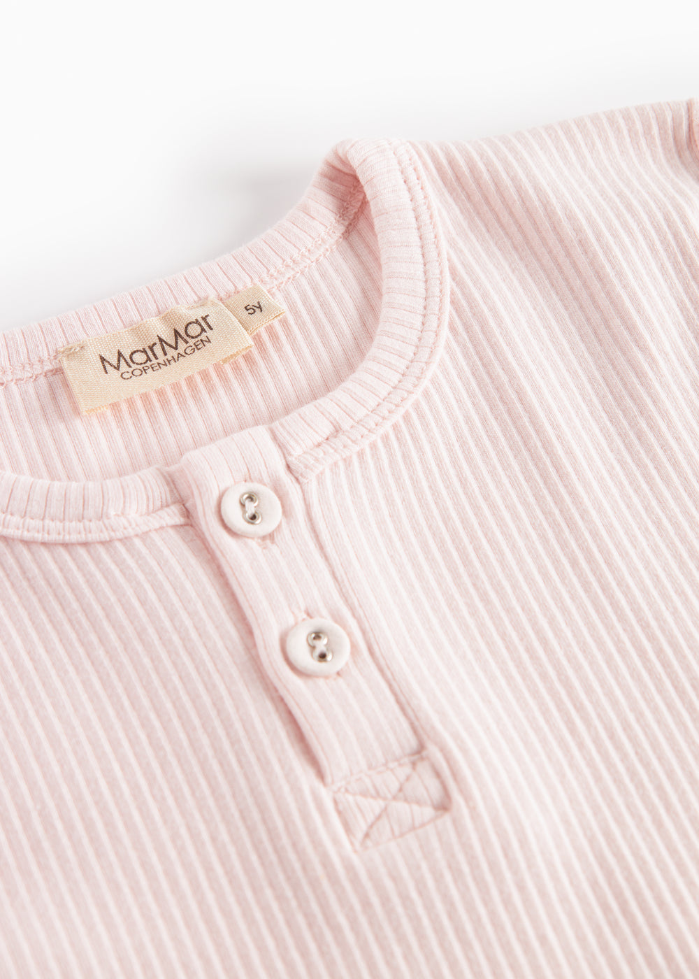 Detalje: lys rosa T-shirt med knaplukning og ribkanter ved hals