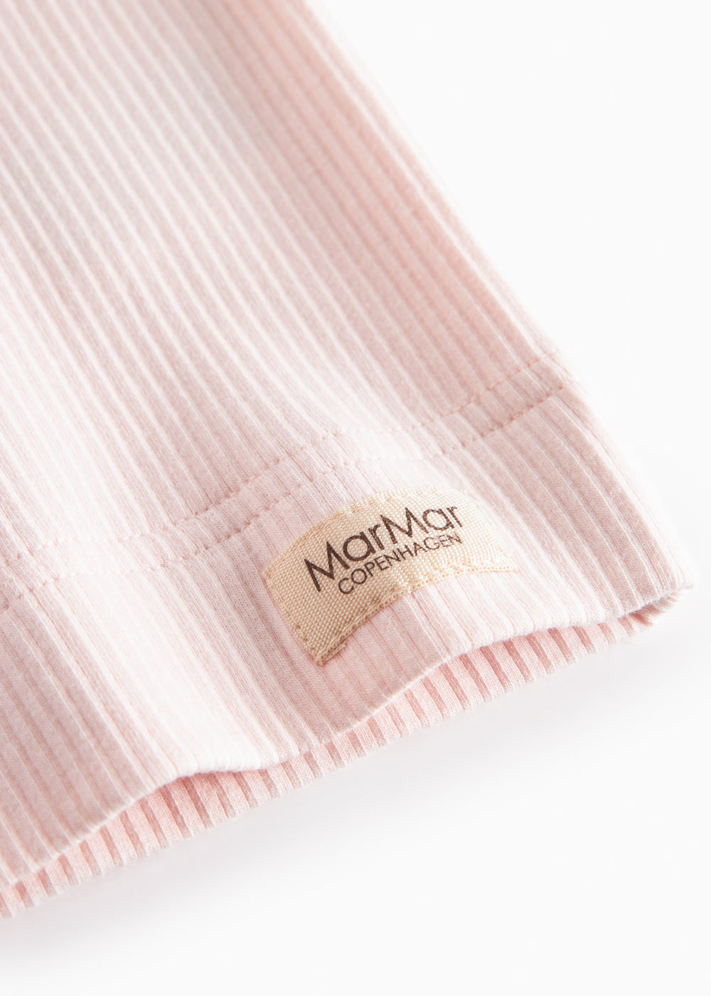 Detalje ved kant og mærke: Marmar Copenhagen i lys rosa T-shirt