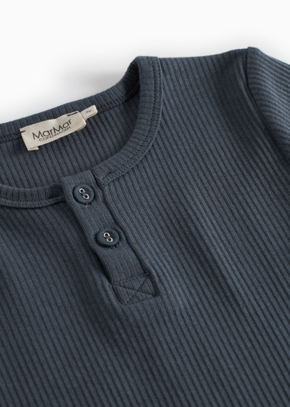 Detalje af børne-T-shirt i mørkeblå ribstrik med knapstolpe og rund hals