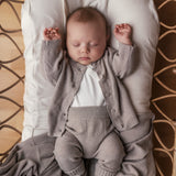 Barn med beige strikket babytæppe