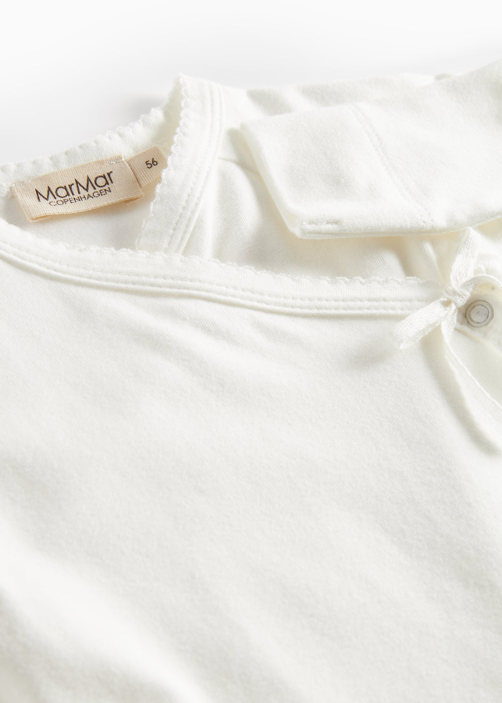 Hvid bodystocking med MarMar Cotton-mærke ved halsen og knapkrave