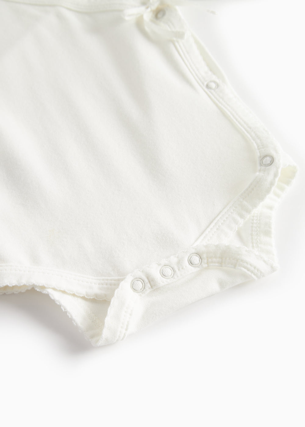 Hvid bodystocking med knaplukning ved ben og sømme langs kanten