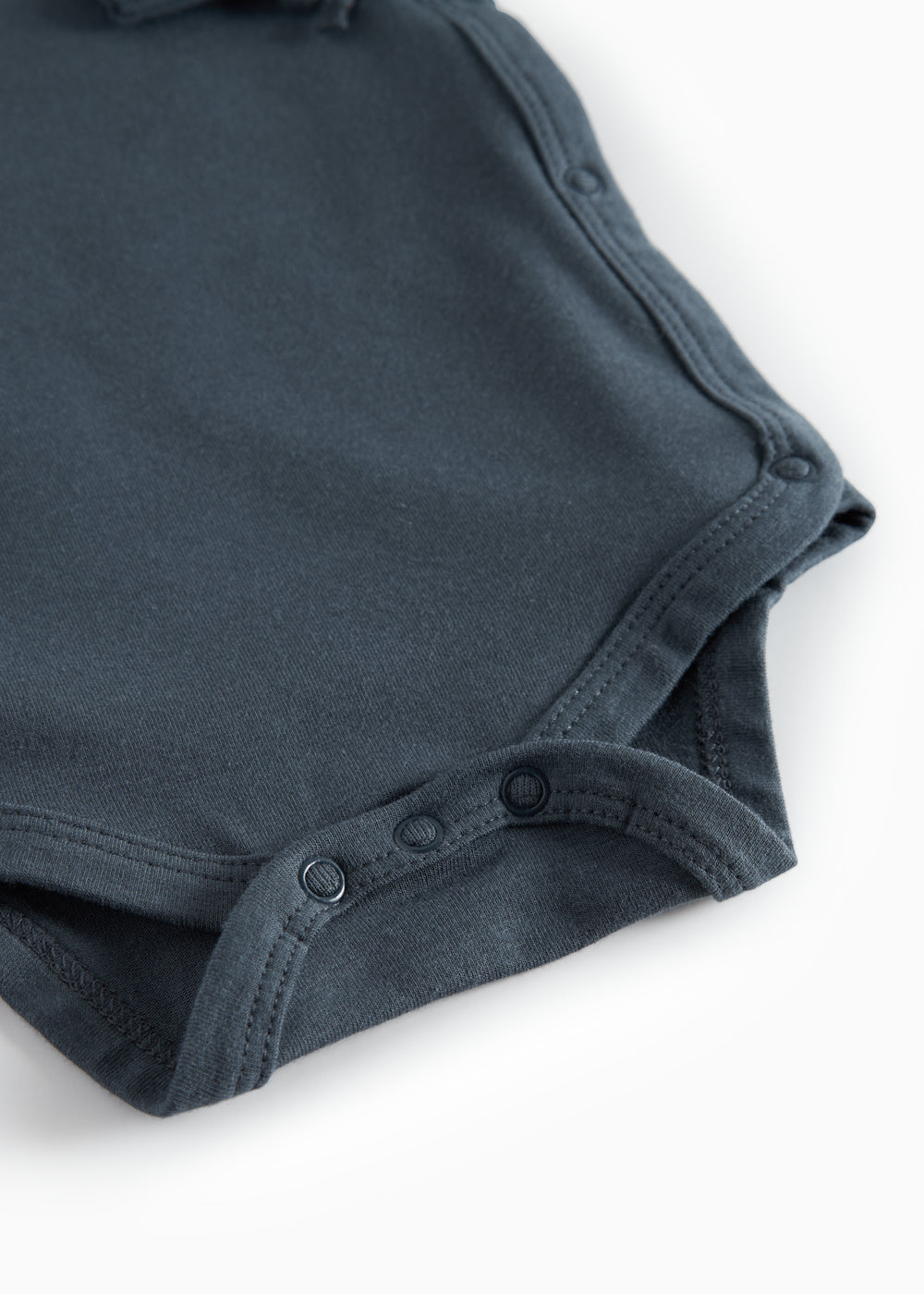 Mørkeblå bodystocking med knaplukning i skridtet og blød kant, close-up