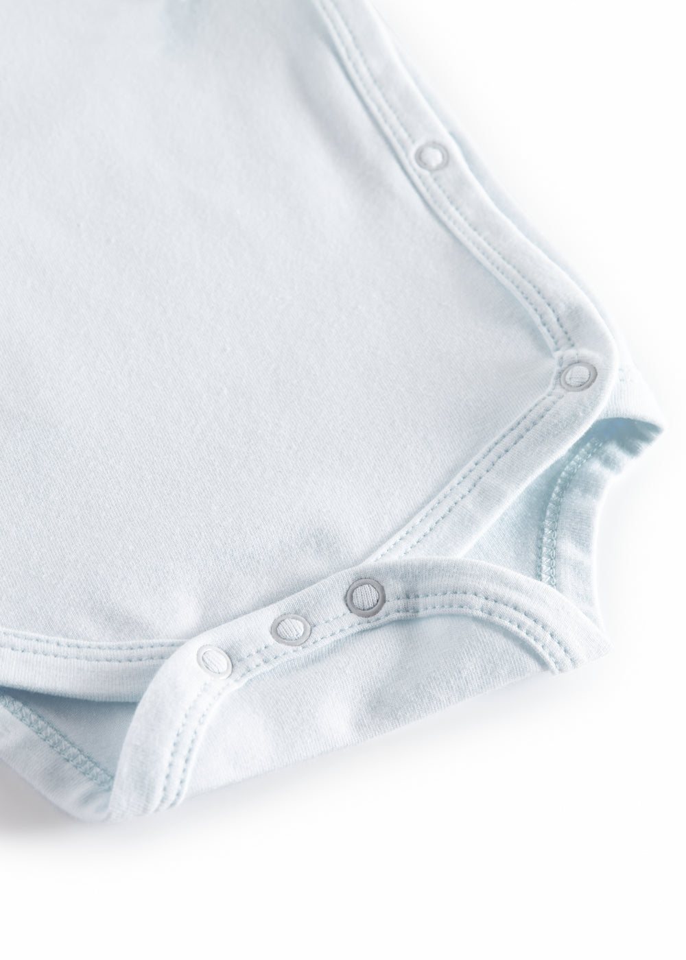 Lyseblå babybody med trykknapper ved skridtet og skrå sømkanter