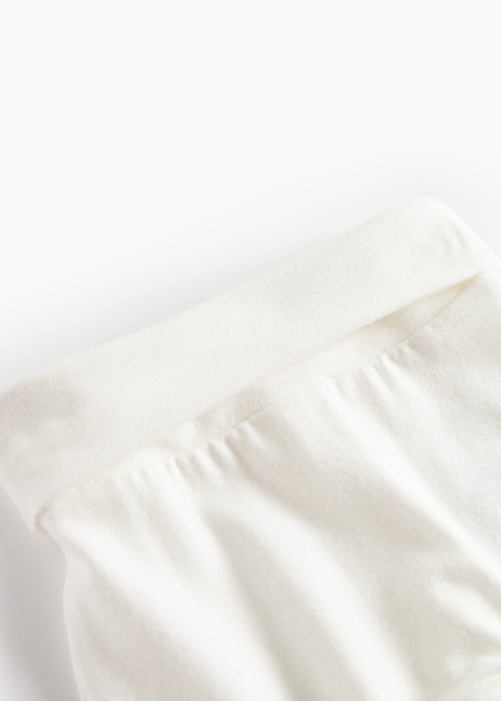 Hvide babybukser med elastisk linning og let rynket stof ved taljen