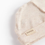 Lys beige melange babys-hue med Marmar-mærke og foldkant, tæt strikket tekstur