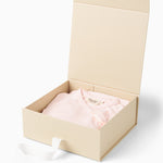 Åben beige gaveæske med pink body og matchende bukser