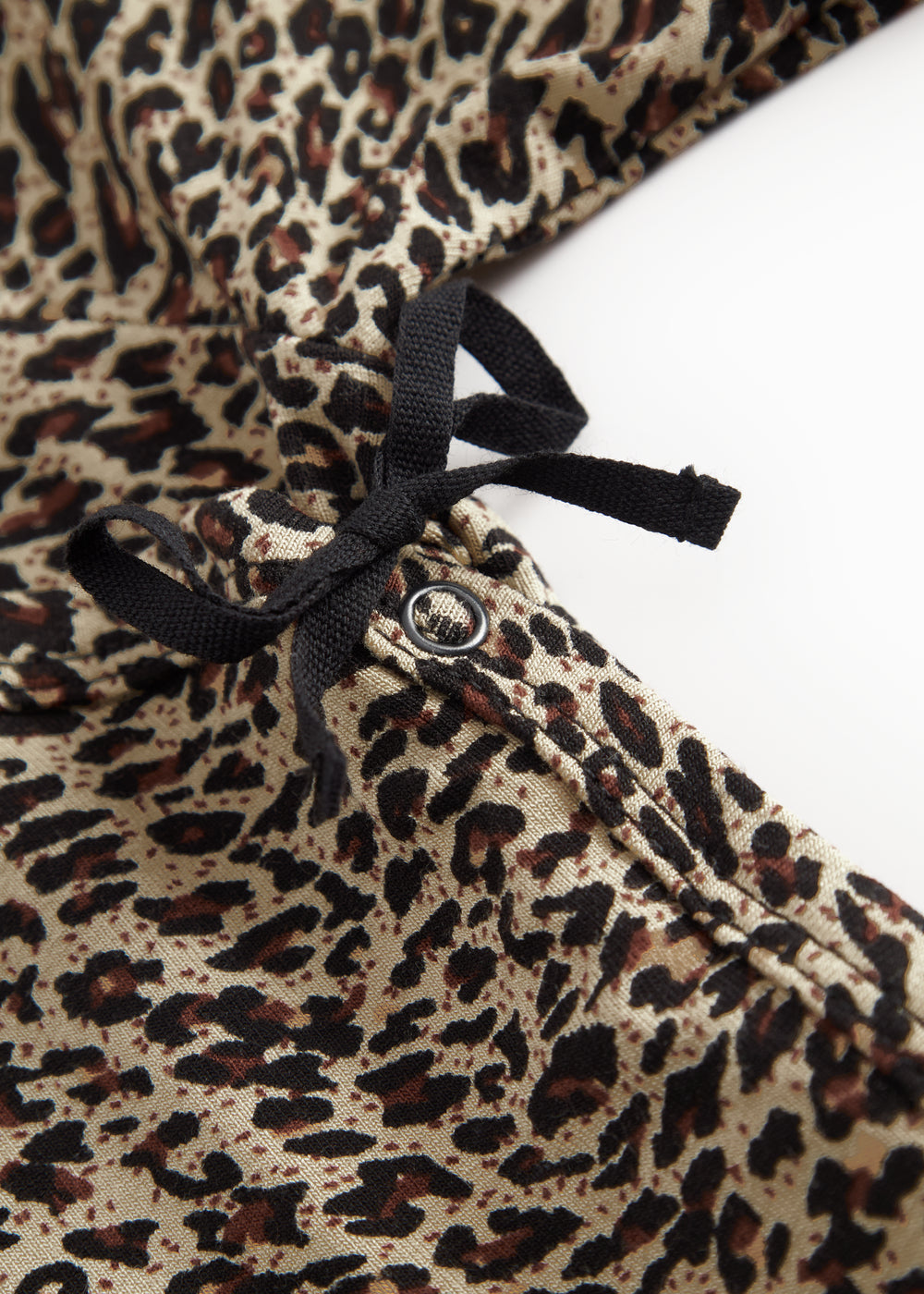 Leopadmønstret bodystocking i brunt med sort sløjfe og knapdetalje ved halsen