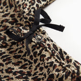 Leopadmønstret bodystocking i brunt med sort sløjfe og knapdetalje ved halsen