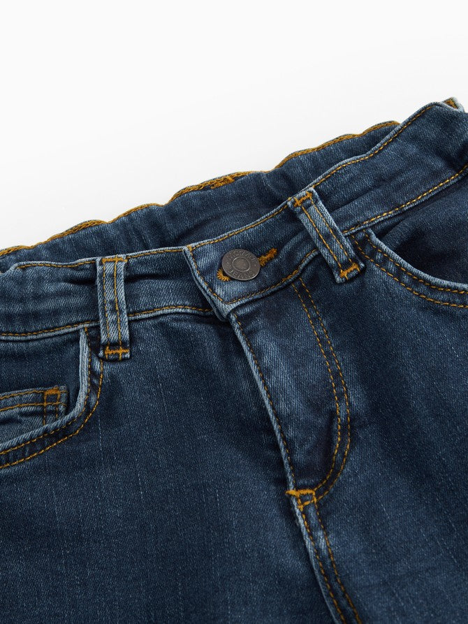 Mørke indigo jeans med knaplukning, bæltestropper og gul syning