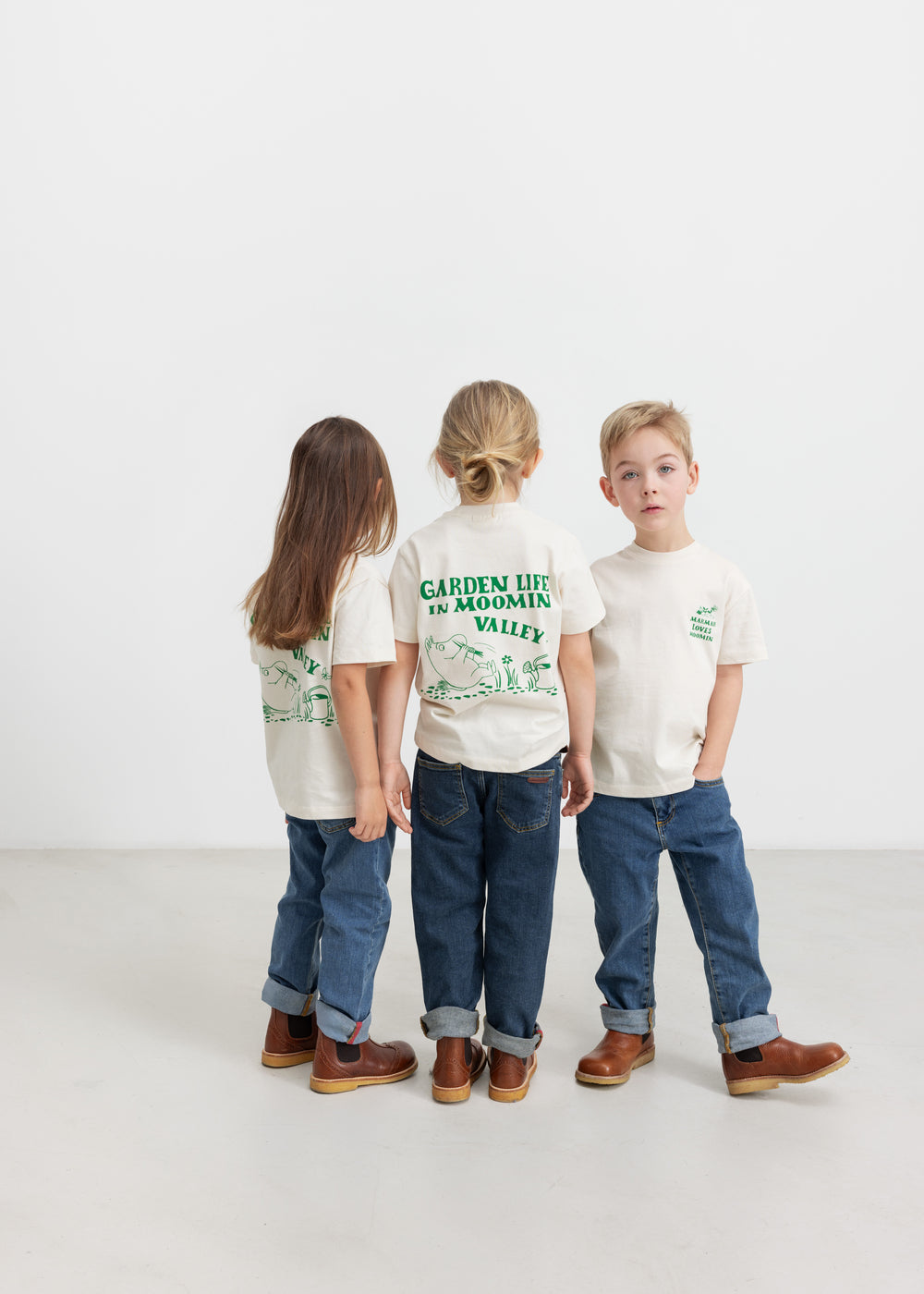 Tre børn iført T-shirts med grønt Moomin print 