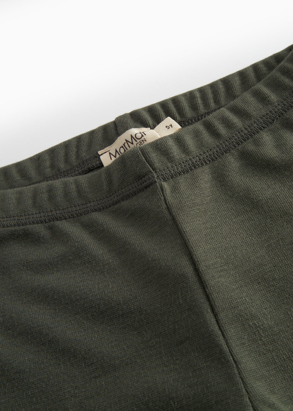 Detalje af elastisk talje på mørkegrønne børneleggings med logo-label