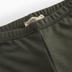Detalje af elastisk talje på mørkegrønne børneleggings med logo-label