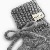Detalje af grå strikket babybootie med MarMar-mærke og sløjdebånd