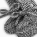 Nærbillede af grå strikket babybootie med sløjhedetalje over ribkant