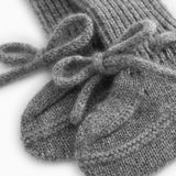 Nærbillede af grå strikket babybootie med sløjhedetalje over ribkant