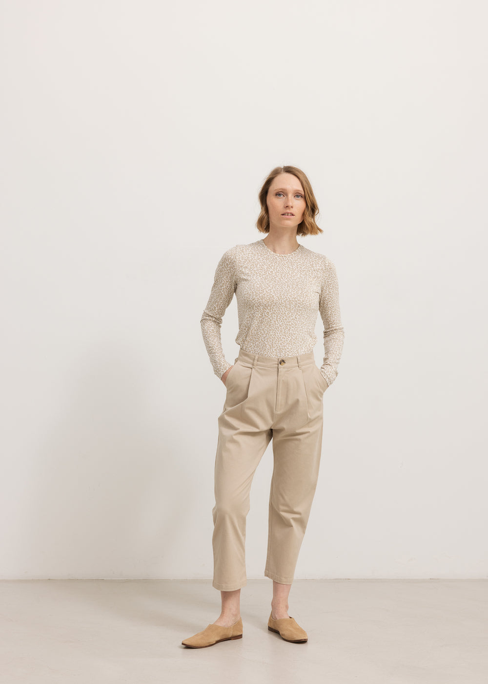 Beige 7/8-bukser med bæltestropper, knap-/lynlåslukning og skrålommer