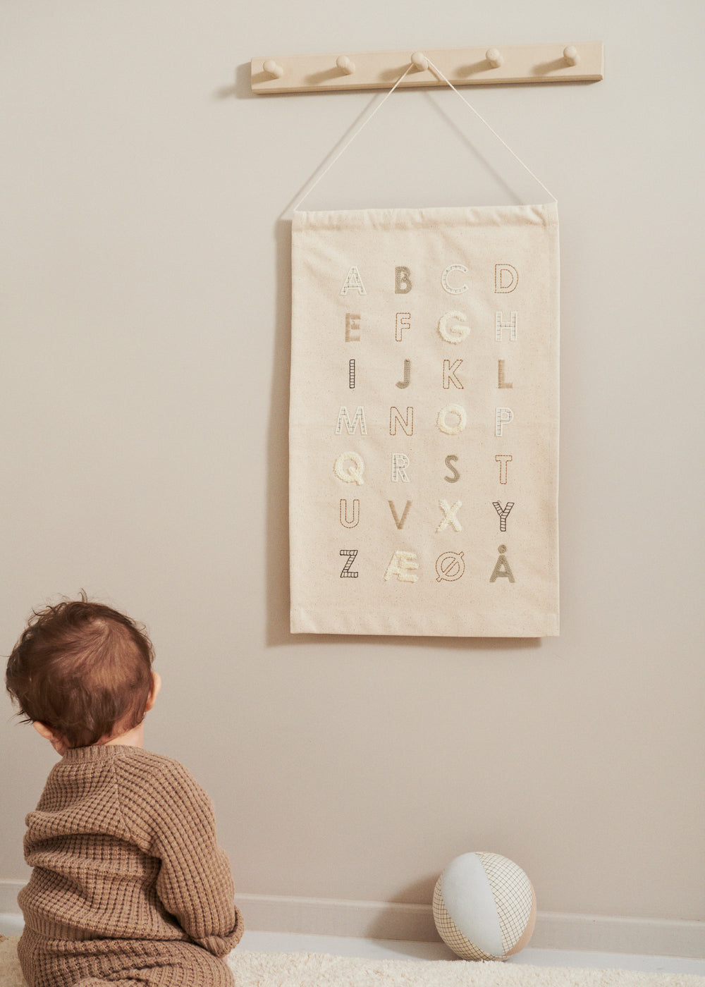 Aktivitetsbold beige/hvid med ternet netmønster på gulvet i hjørnet