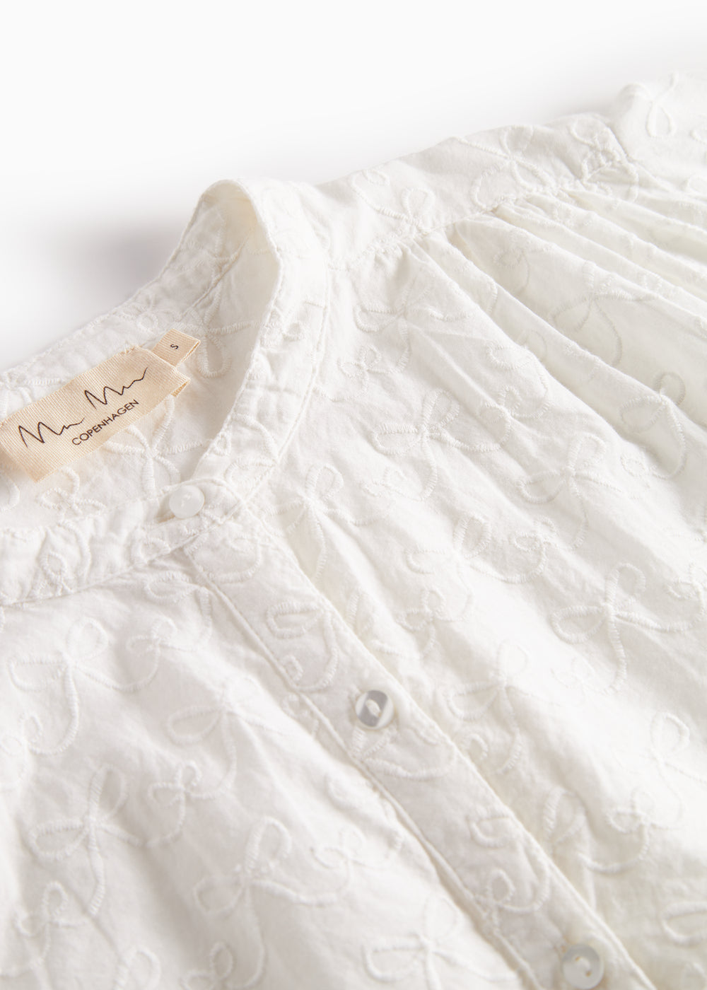 Detaljer af blusens broderede mønster på brystet