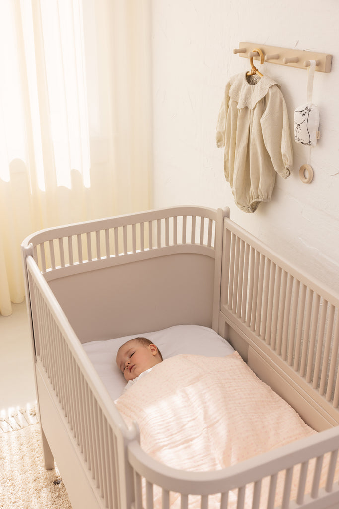 Baby sengetøj i lyse nuancer i tremmeseng: dyne og lagen