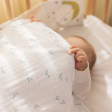 Babysengetøj i hvidt med små delfinprint i blå og grønne nuancer