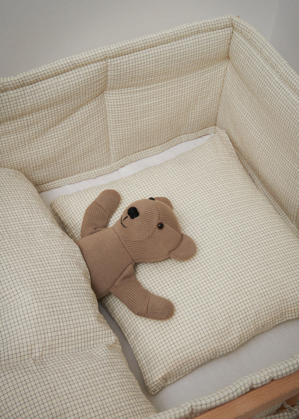 Babysengetøj i beige tern med pude og udstoppet hund i seng