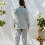 Lyseblå stribet pyjamasæt set bagfra: langærmet skjorte og bukser med elastik