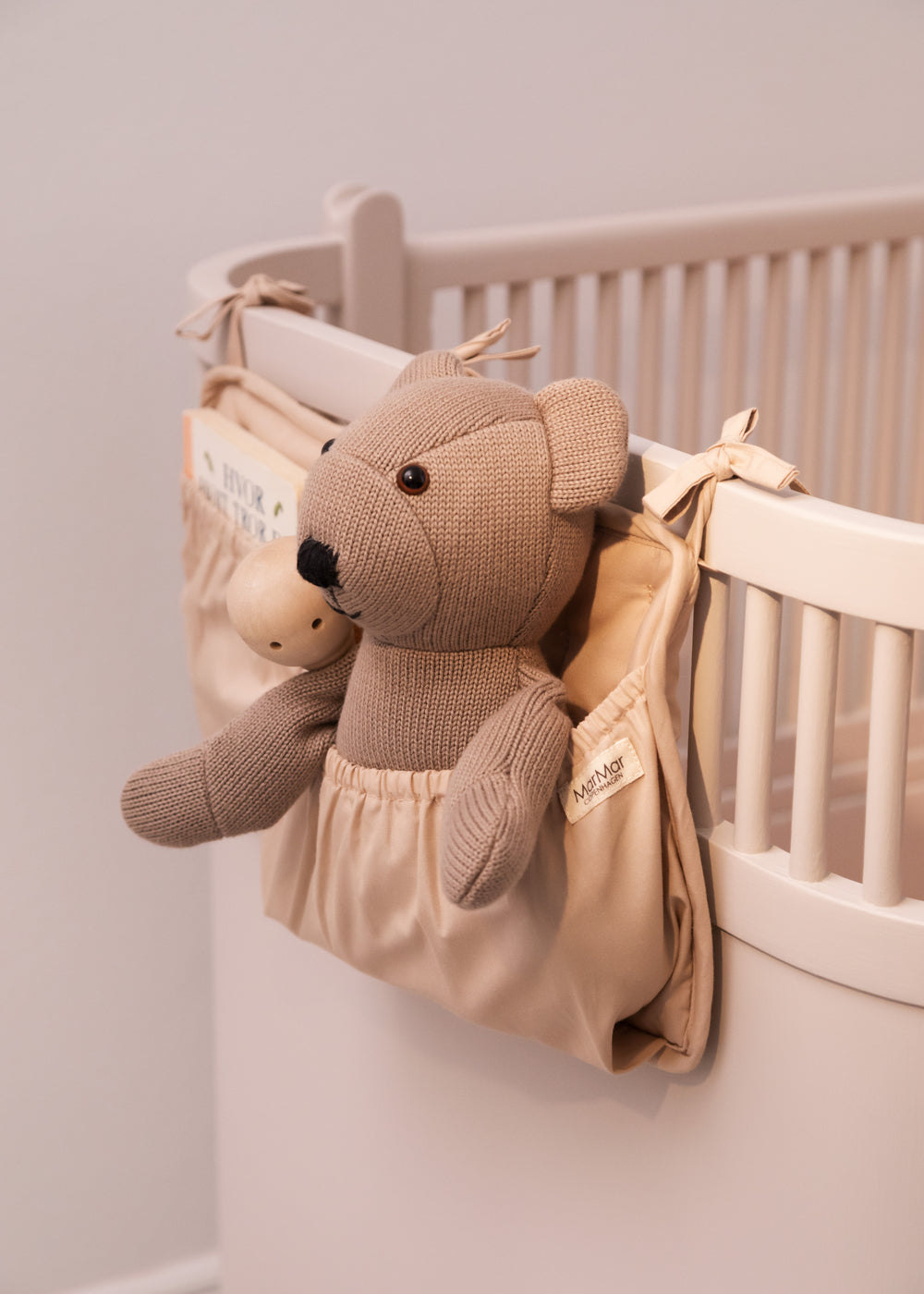 Bamse i varm stentone med broderet snude og ører, i vægophæng i vugge