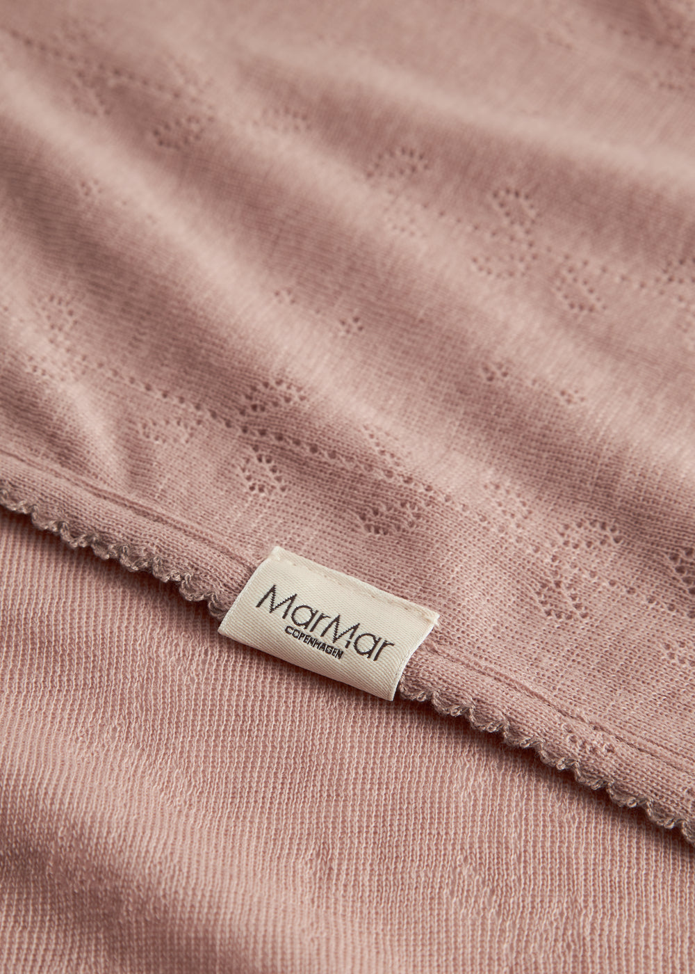 Baby tæppe brændt rosa med pointellemønster og Marmar-label ved kant