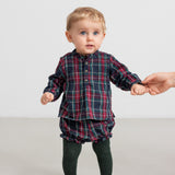 Baby iført mørkeblå og rød ternet skjorte og bloomers