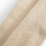Detalje af beige strømpebuksstof med fin guldsparkle og glitrende tekstur