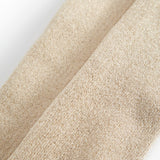 Detalje af beige strømpebuksstof med fin guldsparkle og glitrende tekstur