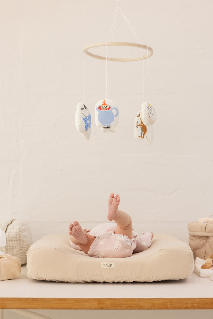 Langærmet bodystocking i lyserød med Moomin-tryk, på baby på pude