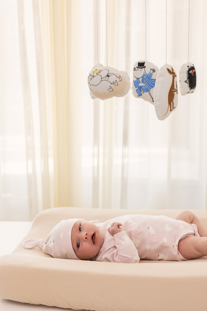 Lyserød langærmet bodystocking med små Moomin-motiver, på baby