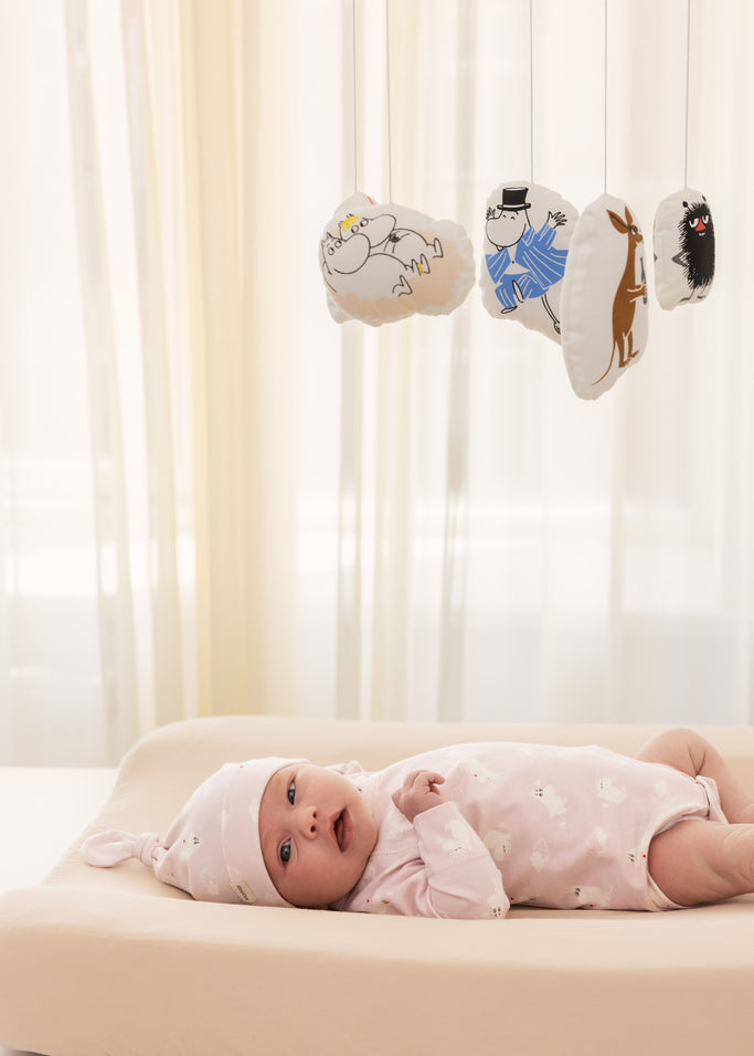 Lyserød langærmet bodystocking med små Moomin-motiver, på baby