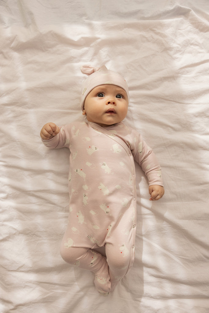 Rosa babyheldragt med lange ærmer og ben, samlet trykknaplukning og små Moomin-figurer