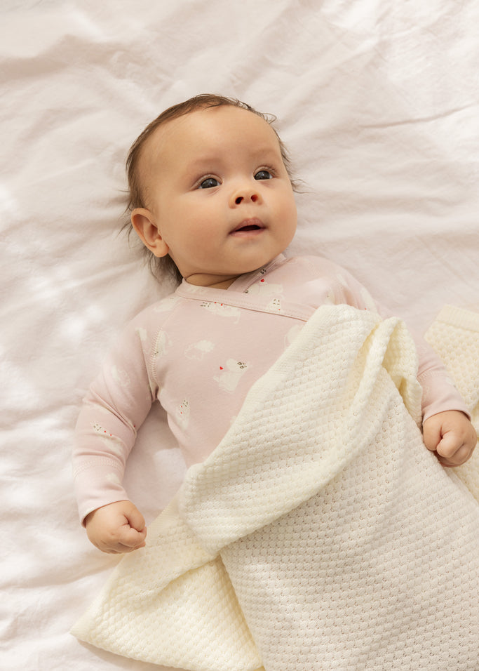 Rosa babyheldragt med lange ærmer og heldragtben, allover Moomin-tryk og trykknaplukning