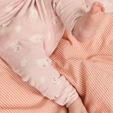 Babysengetøj i lyserød med små dyr og orange/hvide striber, samt matchende pude