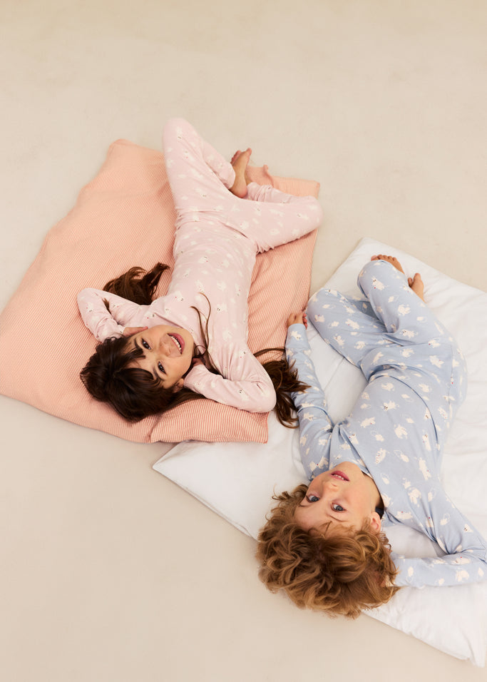 Børnepyjamas i lyseblå og lyserød med lange ærmer og heldragt-lignende mønster