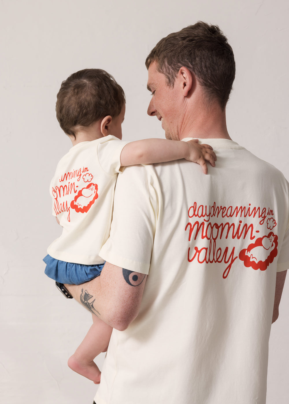 Voksen og baby set bagfra iført matchende T-shirts med Mumin-print