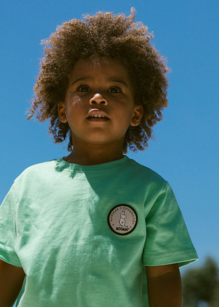 Børne-T-shirt i mintgrøn med rund hals og lille rund patch på brystet