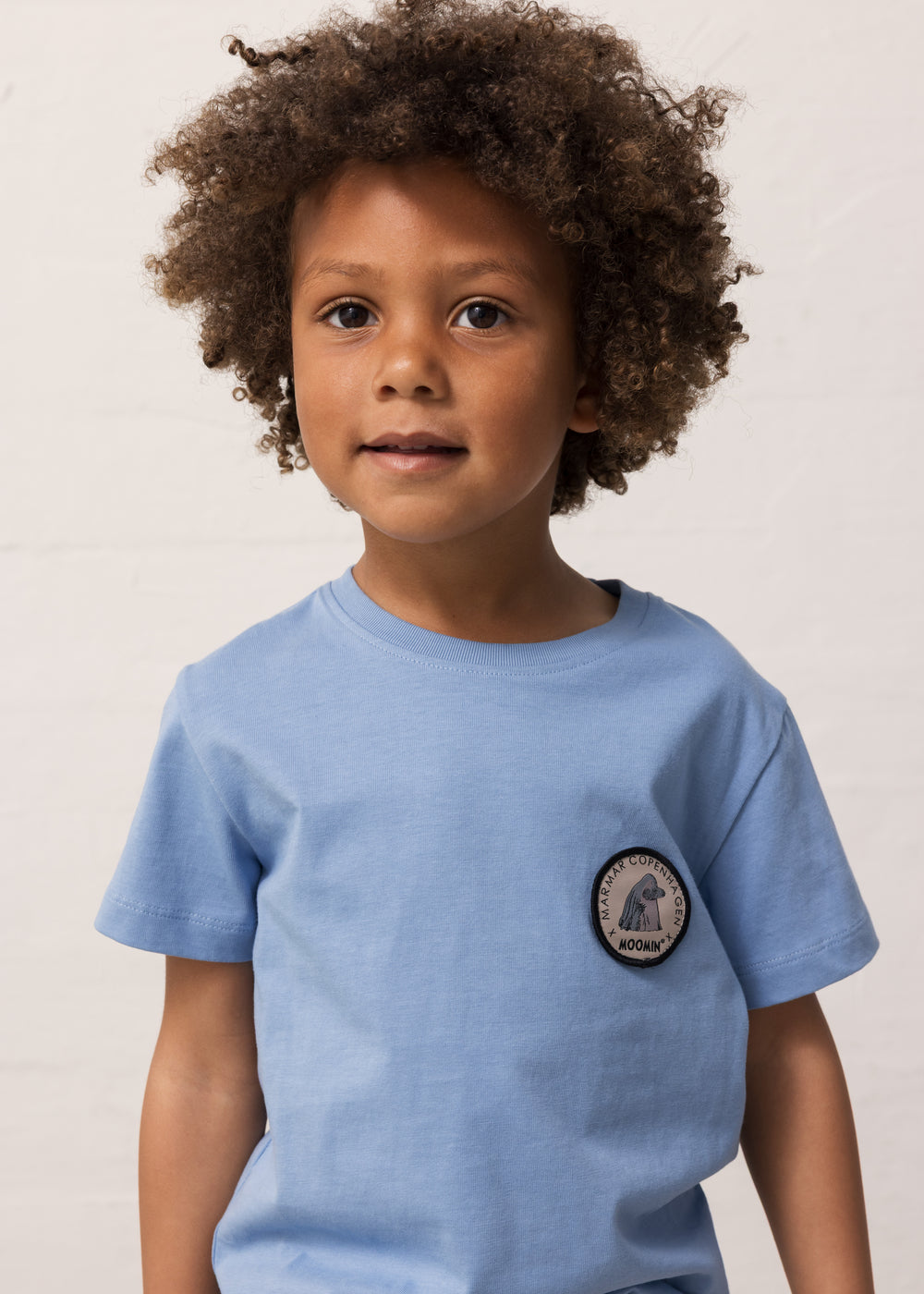 Lyseblå børne-T-shirt med rund brystpatch og korte ærmer