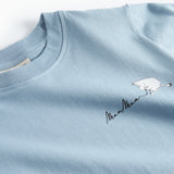 Lyseblå T-shirt med rund hals og lille Moomin-logo ved brystet