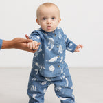 Blå baby-skjorte i denim med knaplukning og Moomins-mønster på barnet.